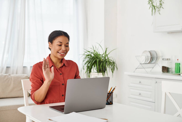 щасливий афроамериканський дієтолог, що надає онлайн-консультацію на ноутбуці з її кухні - Фото, зображення
