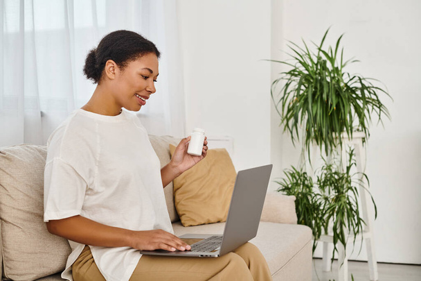 african american nutritionist with supplements giving dietary advice via laptop in living room - Photo, Image