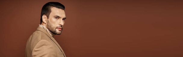 handsome man in elegant attire giving confident look while posing on beige background, banner - Photo, Image