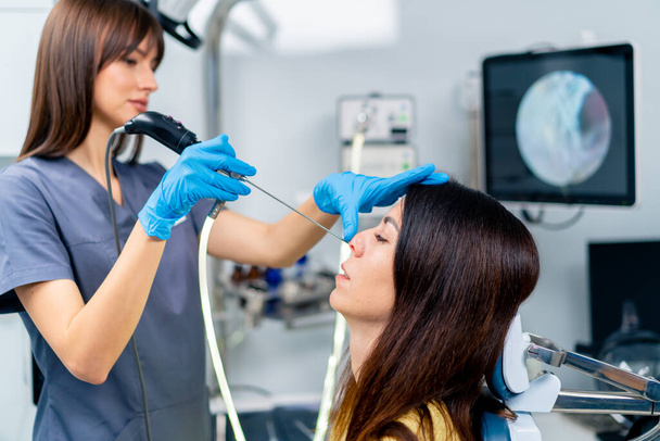 ЛОР-лікар виконує процедуру ендоскопії носа пацієнта в клініці, що тримає в руці професійний пристрій - Фото, зображення