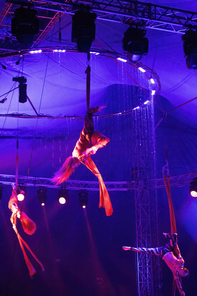 München, 13. Dezember 2023: Zirkusartisten führen Akrobaten auf Leinwänden auf. Ein niedliches Team führt akrobatische Elemente in der Luft auf. - Foto, Bild