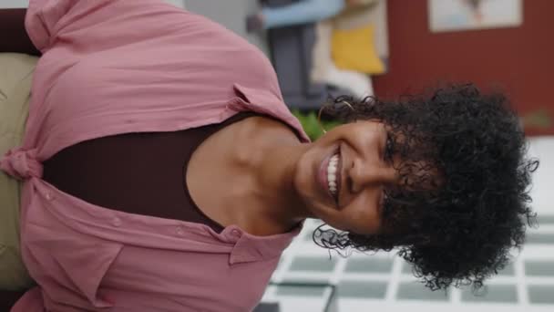 Retrato médio vertical de jovem mulher birracial exótica com belo sorriso de dente posando para câmera no apartamento estúdio moderno - Filmagem, Vídeo