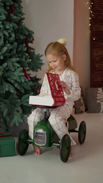 Close-up portret van vrolijk Kaukasisch meisje openen kerst geschenkdoos met verrast gelukkig gezicht. Een mooi kind ontvangt een kerstcadeau met een opgewonden gezicht. - Video
