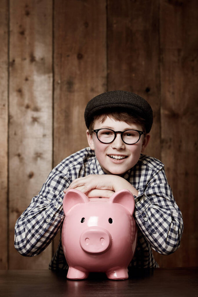 Sparschwein, Lächeln und Porträt eines Jungen mit Ersparnissen, Wachstum oder Anlageerfolg in seinem Haus. Finanzen, Lernen und Gesicht des aufgeregten Kindes mit Spardose für zukünftige Bildung, Finanzierung oder Sicherheit. - Foto, Bild