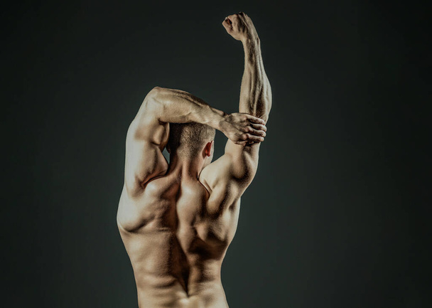 Male body shape, strong man. Athletic young man posing shirtless. Man Power. Perfect Shoulders and Back Muscles. Muscular Man showing Strength, Back view. Sexy body. Strong Shoulders. Muscular model - Фото, зображення