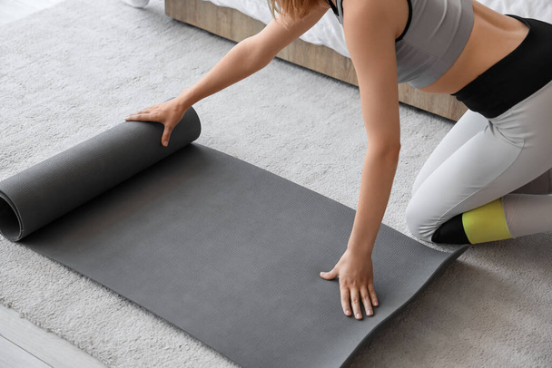 Junge sportliche Frau mit Yogamatte zu Hause - Foto, Bild