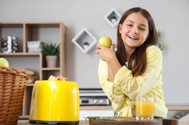 Aranyos kislány friss almával a konyhában - Fotó, kép