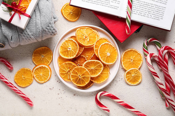 Lemez szárított narancs szeletek és karácsonyi cukornád fehér alapon - Fotó, kép