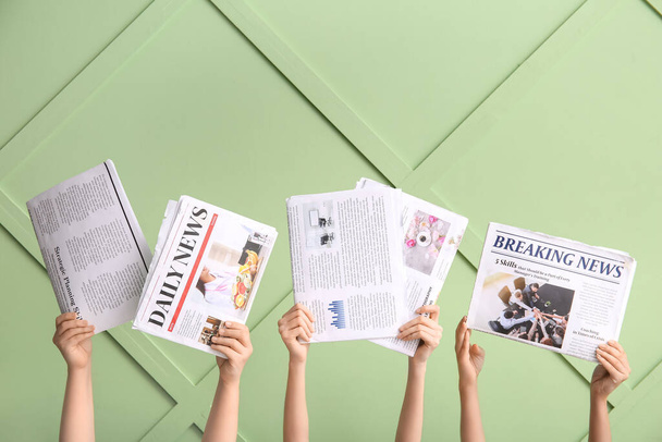 Frauenhände mit verschiedenen Zeitungen gegen Farbwand - Foto, Bild