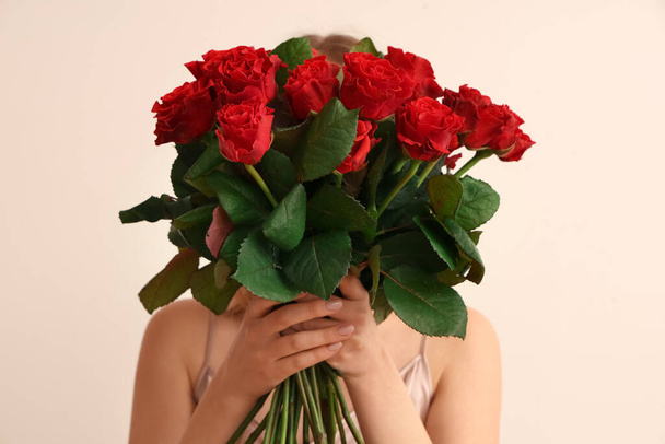 Junge Frau mit einem Strauß schöner roter Rosen auf weißem Hintergrund. Valentinstag-Feier - Foto, Bild