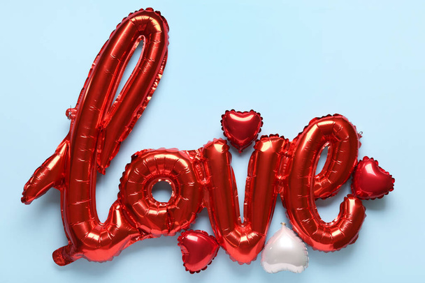 Luchtballonnen in de vorm van woord LIEFDE op blauwe achtergrond. Valentijnsdag - Foto, afbeelding