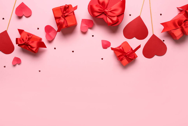 Ajándék dobozok papírszívvel és konfettivel rózsaszín háttérrel. Valentin-napi ünneplés - Fotó, kép