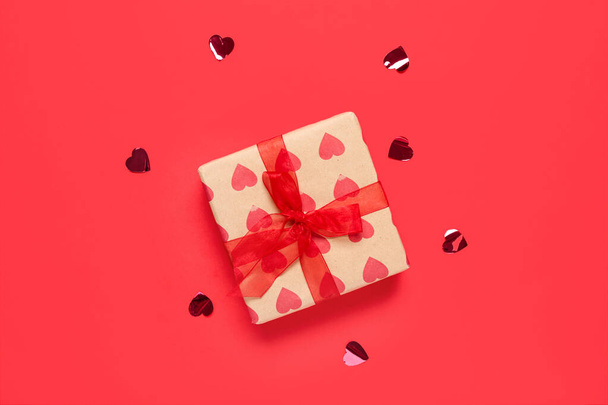 Подарункова коробка і конфетті на червоному тлі. Святкування Дня святого Валентина - Фото, зображення