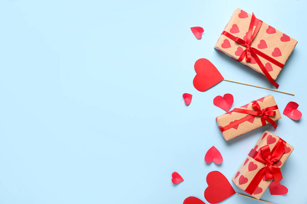 Gift boxes and paper hearts on blue background. Valentine's Day celebration - Photo, Image