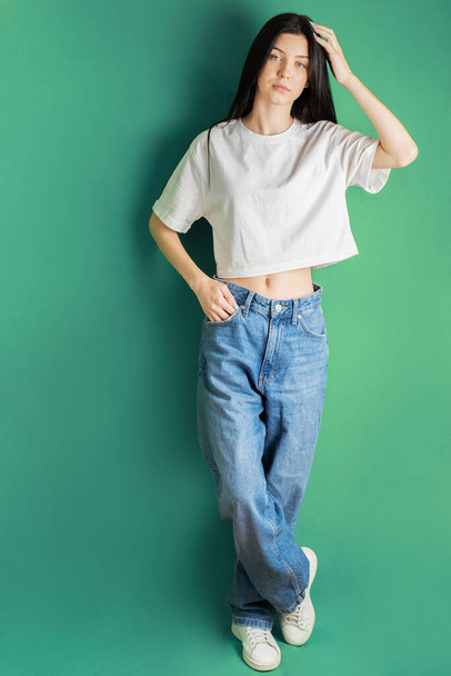Retrato de larga duración de una joven adolescente con una camiseta blanca y jeans. - Foto, Imagen