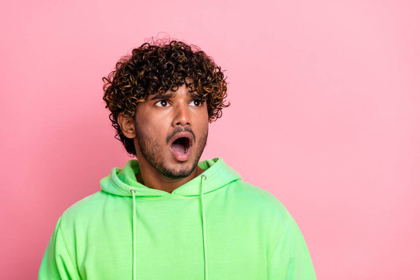 Photo of young poor student indian guy wear green trendy hoodie amazed steam autumn sale look empty space isolated on pink color background. - Photo, Image