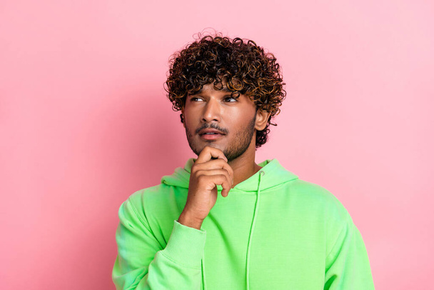 Portrait of indian young serious guy brainstorming touching chin pensive deep thinking look empty space isolated on pink color background. - Фото, зображення