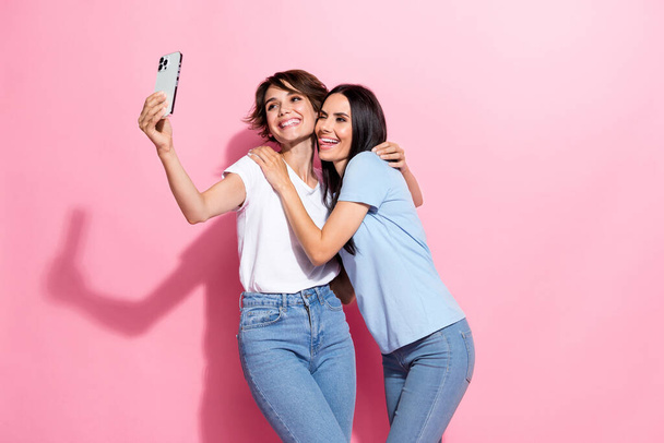 Photo of relatives two best friends girls hugs together chill selfie cadre portrait have fun shopping isolated on pink color background. - Foto, Imagen