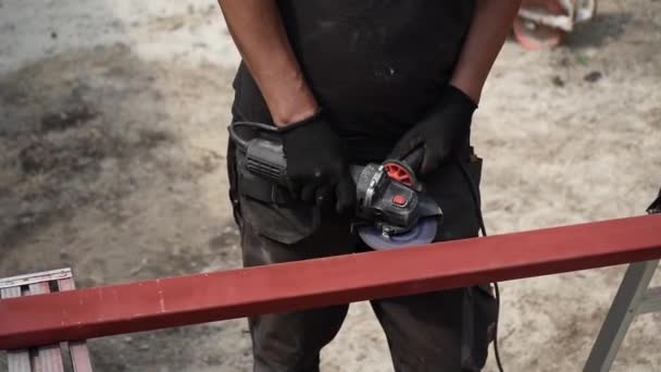 El trabajador utiliza una amoladora angular que produce. Trabajador moliendo metal. Retire el óxido. Brillantes chispas y destellos - Imágenes, Vídeo