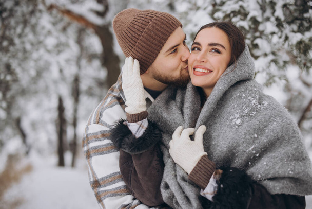 Nuoren onnellisen ja rakastavan parin muotokuva hauskaa lumisessa metsässä - Valokuva, kuva