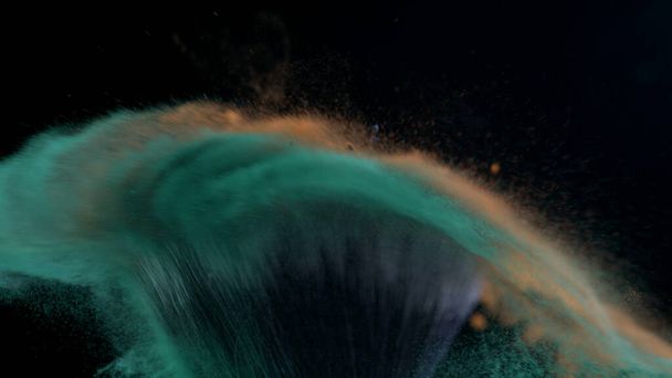 Macro primer plano del cepillo cosmético chocando en cámara súper lenta capturado con una cámara de alta velocidad a 1000 fps con polvo naranja y verde volando en el aire - Foto, imagen