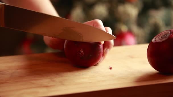La mano de la mujer cortando cebolla roja en el primer plano de madera  - Imágenes, Vídeo