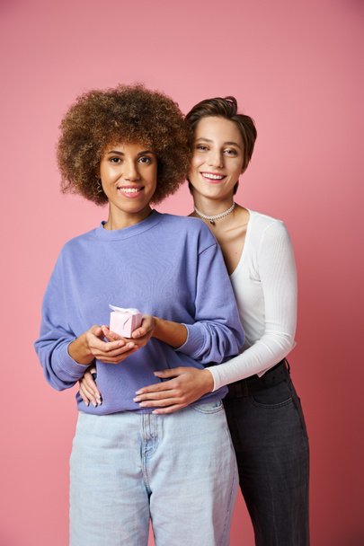 cheerful lesbian woman hugging happy african american girlfriend with present on Valentins day - Photo, Image