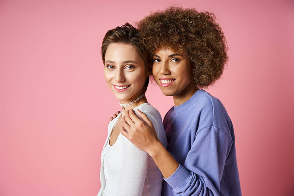 portrait of young multicultural lgbtq couple in casual clothes looking at camera on pink background - Foto, Imagem