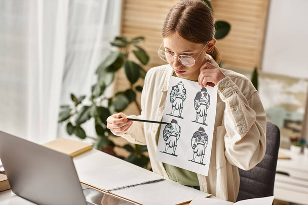 Jeune adolescente analysant des dessins d'anatomie pour un cours d'art en ligne à la maison, regardant un ordinateur portable - Photo, image