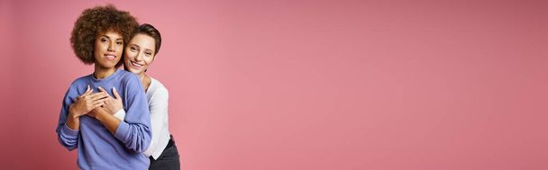 happy woman hugging her african american girlfriend on pink background, lgbtq couple love banner - Foto, Imagem