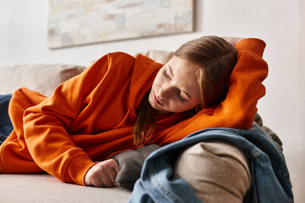 подавленный ген z девушка лежит на диване в гостиной, одиночество и меланхолия подростковой концепции - Фото, изображение