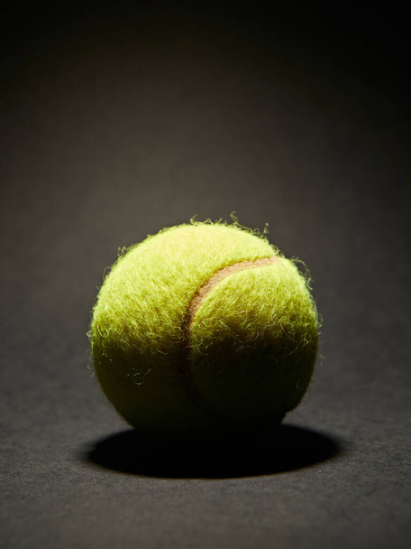 Тенісний м'яч на чорному тлі з пробілом для копіювання вашого тексту. - Фото, зображення
