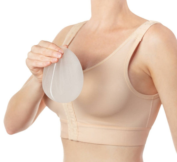 Женщина держит имплантат в руке изолирован на белом фоне с обрезкой пути. Копирование пространства - Фото, изображение