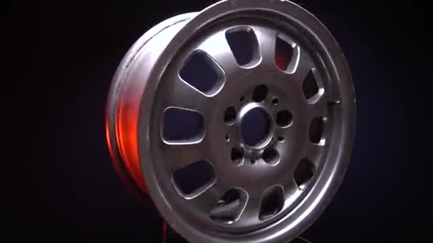 old uneven car titanium rims of silver color in red light in dark room - Footage, Video
