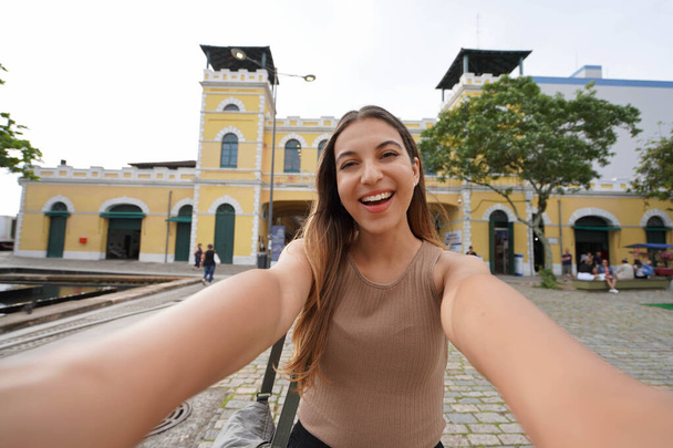 Lächelndes Mädchen macht Selfie vor dem öffentlichen Markt von Florianopolis, Santa Catarina, Brasilien - Foto, Bild