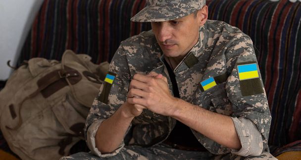 Військовий чоловік сидить вдома в думках
 - Фото, зображення