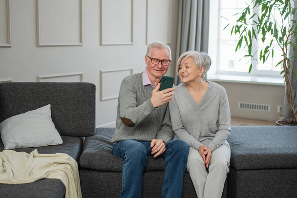 Videohovor. Šťastný starší pár žena muž s chytrým telefonem mají videohovor. Starší babička děda mluví online. Starší generace moderních technologií. Virtuální schůzka online chat - Fotografie, Obrázek