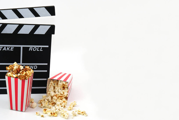 Clapperboard o film ardesia colore nero con popcorn su sfondo bianco. Industria cinematografica, produzione video e concetto di film. - Foto, immagini
