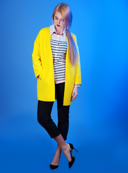 Fashion portrait of blond woman in trendy yellow jacket over blu - Zdjęcie, obraz