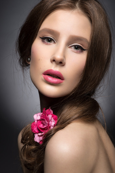 Beautiful girl with pink lips and a rose in her hair.  Beauty face. - Valokuva, kuva