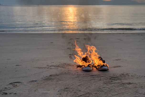 un par de zapatillas en llamas a la izquierda en la playa - Foto, imagen
