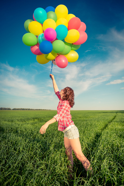Woman with toy balloons in spring field - Foto, afbeelding