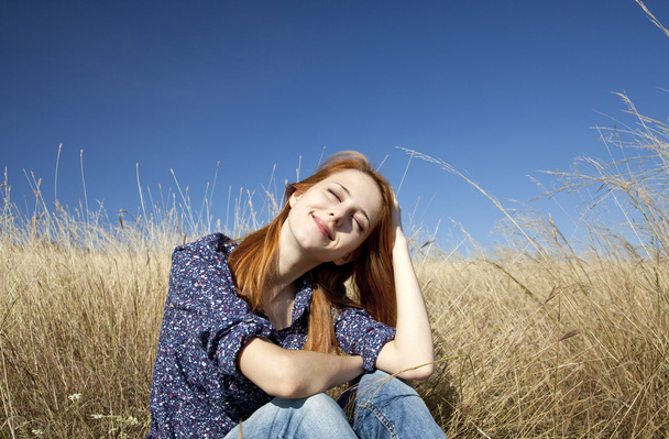 Portrait of happy red-haired girl on autumn grass. - Photo, Image