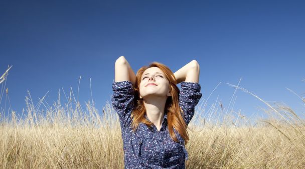 portret szczęśliwy rudowłosej dziewczyny na jesień trawa. - Zdjęcie, obraz