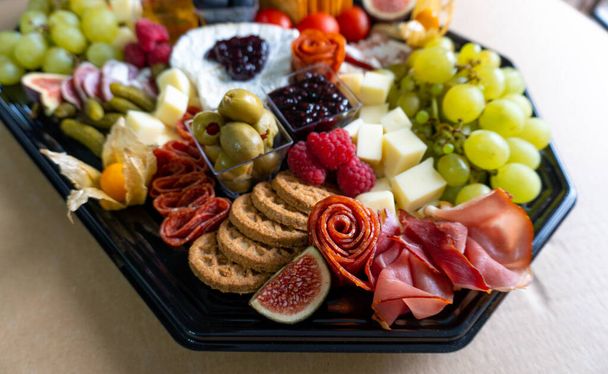 Charcuterie Board friss gyümölcsökkel, húsokkal és sajtokkal - Fotó, kép