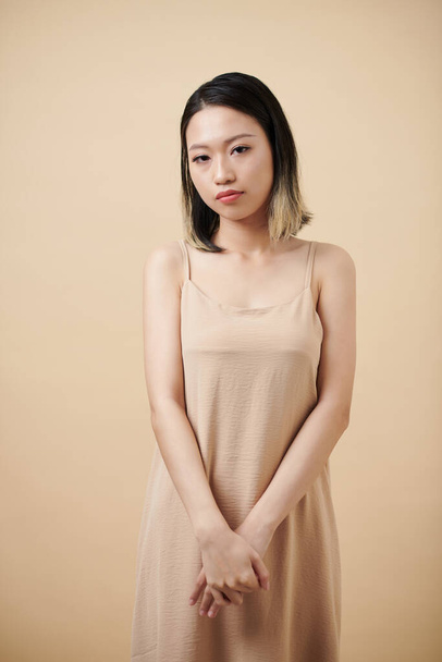 カメラを見ているシルクドレスで恥ずかしい若いアジアの女性の肖像画 - 写真・画像