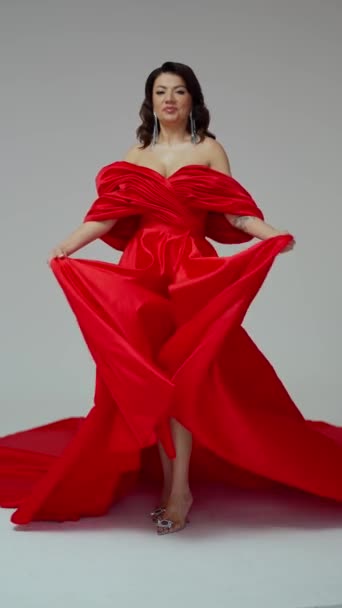 Жінка в розкішній червоній вечірній сукні на білому фоні студії, дама королева, модель - Кадри, відео