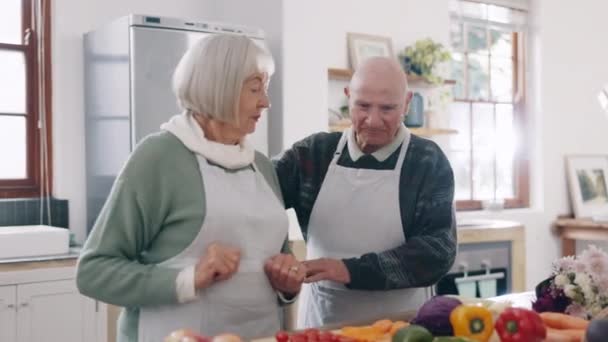Cooking, happy and senior couple in kitchen for lunch, supper and romantic dinner together. Marriage, retirement and man and woman at home with food for meal prep for bonding, fun and happiness. - Footage, Video