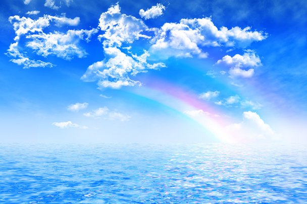 Colorido arco iris en el cielo azul de verano con nubes cúmulos sobre aguas cristalinas
 - Foto, Imagen
