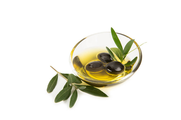 Mísa čerstvého olivového oleje a oliv s listy izolovanými na bílém pozadí. Lahodný olivový olej ve skleněné misce. láhev olivového oleje. - Fotografie, Obrázek